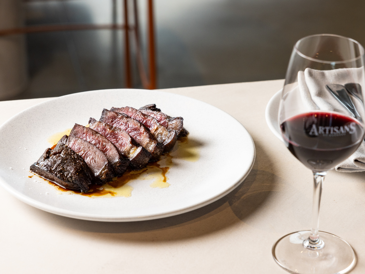 Sliced Porterhouse steak served with red wine at Artisans of Barossa's Football & Fries steak night in the Barossa Valley.