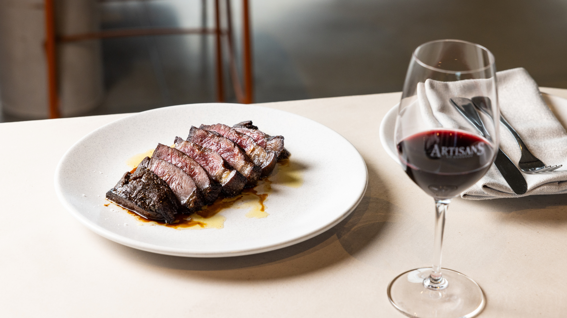 Sliced Porterhouse steak served with red wine at Artisans of Barossa's Football & Fries steak night in the Barossa Valley.